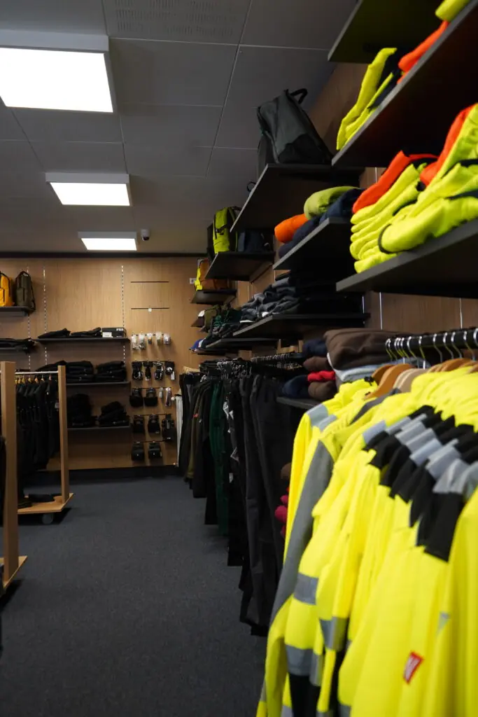Arbeitskleidung in Signalfarben und dunklen Tönen im Verkaufsraum von MP Berufsbekleidung.