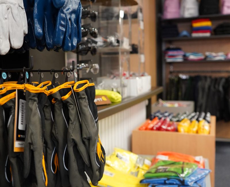 Verschiedene Arbeitshandschuhe und Schutzkleidung im Verkaufsbereich von MP Berufsbekleidung.