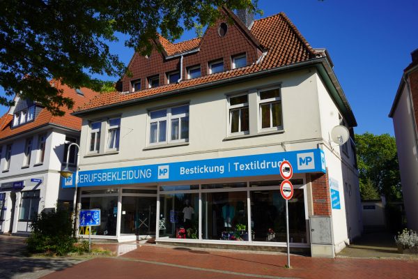 Außenansicht des Geschäfts von MP Berufsbekleidung mit großer Fensterfront und blauer Beschriftung.