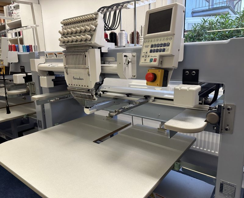 Moderne Mehrkopf-Stickmaschine von Barudan mit digitalem Steuerungsdisplay in der Stickerei-Werkstatt.