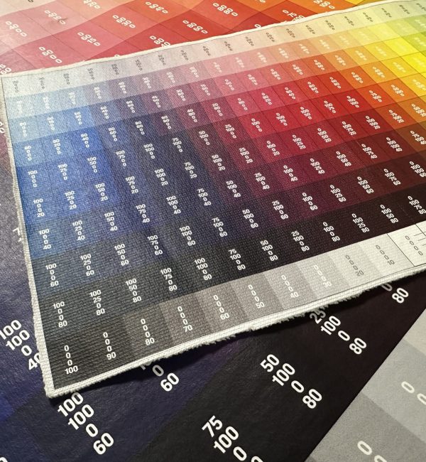 DTF-Druck Farbtest mit CMYK-Farbtönen auf verschiedenen Materialien zur Farbanpassung.